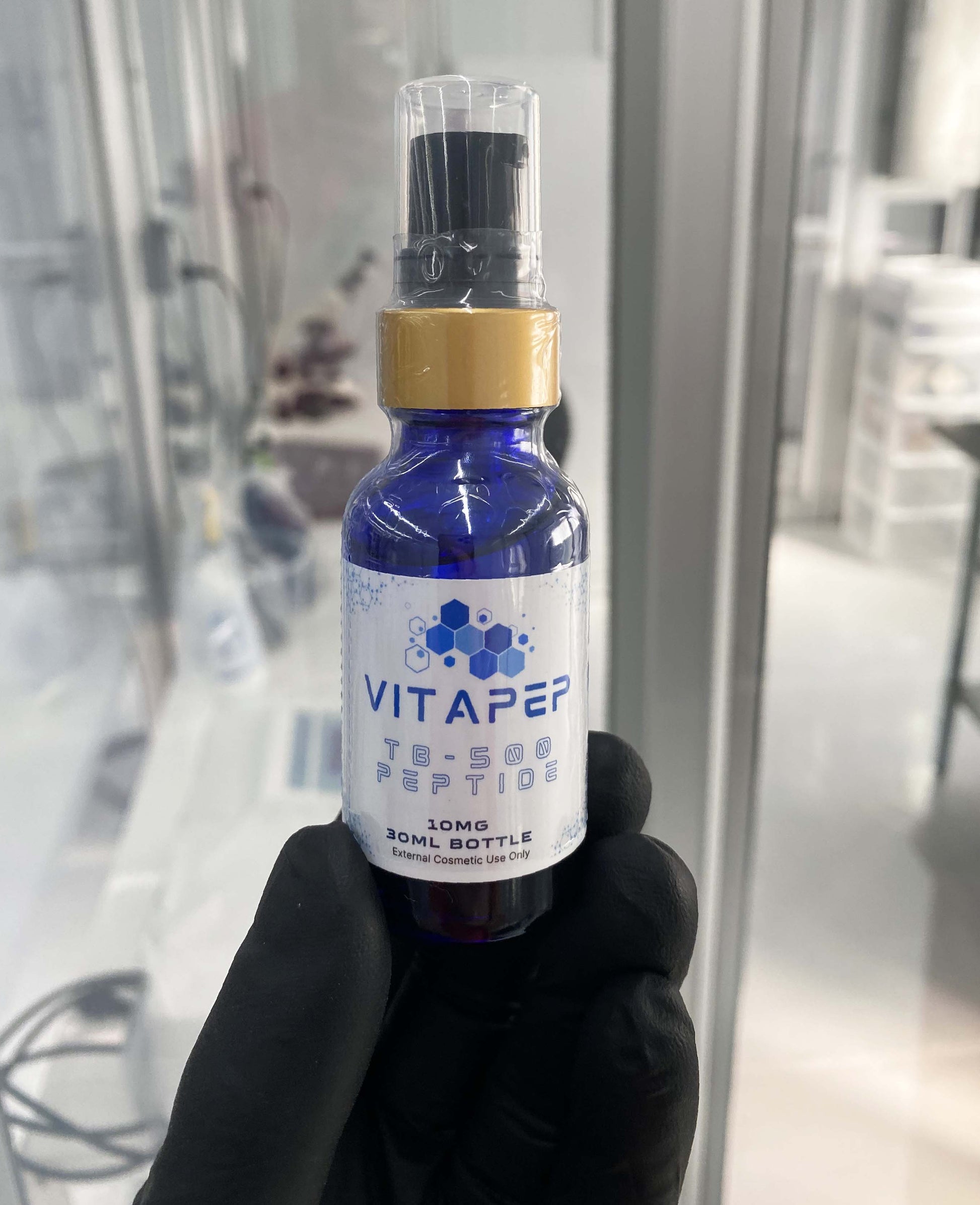 Holding tb-500 peptide cream with a glove in VitaPep Lab